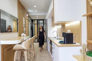 Una mujer caminando por un pasillo en una cocina en Queen Stella Luxury Homes, en Rethymno