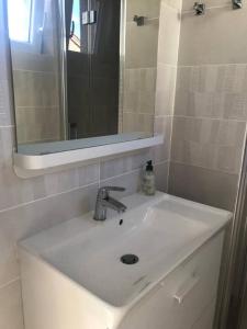 ein weißes Waschbecken im Bad mit Spiegel in der Unterkunft Logement : 2 chambres (5 couchages), salle de bain in Pierrefitte-sur-Sauldre