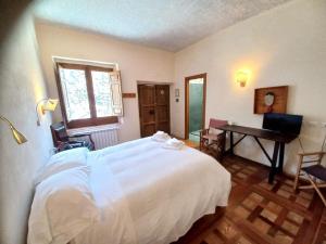 sypialnia z dużym białym łóżkiem i biurkiem w obiekcie Azienda Agricola Il Querceto w mieście Marsico Vetere