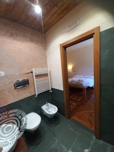 a bathroom with a toilet and a sink and a bed at Azienda Agricola Il Querceto in Marsico Vetere