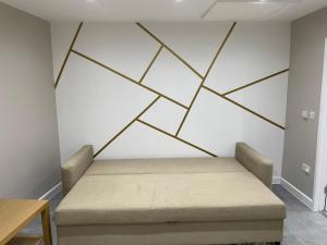 a bed in a room with a geometric wall at One bedroom apartment in Goodmayes