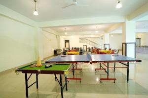 2 mesas de ping pong en una habitación con sillas en Pineland Resorts & Chalets Kasauli, en Kasauli