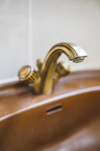 - un lavabo en bronze avec un robinet en laiton dans l'établissement Elmenhof, à Elmenhorst