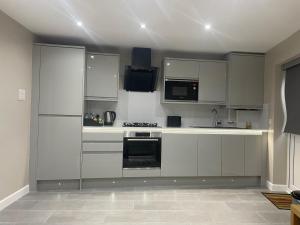een keuken met witte kasten en een fornuis met oven bij One bedroom apartment in Goodmayes