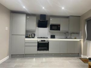 a kitchen with white cabinets and a stove top oven at One bedroom apartment in Goodmayes