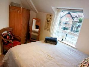 Un dormitorio con una cama grande y una ventana en Bright modern apartment, Shipston-on-Stour en Honington