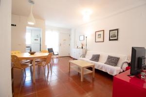 ein Wohnzimmer mit Couch und Tisch in der Unterkunft Global Properties, Apartamento con piscina en playa Corinto in Sagunt
