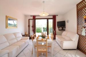 uma sala de estar com um sofá branco e uma mesa em VILLA MAGNOLIA vicino al mare em Ilha Albarella