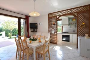 uma cozinha e sala de jantar com mesa e cadeiras em VILLA MAGNOLIA vicino al mare em Ilha Albarella