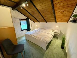 1 dormitorio con 1 cama y 1 silla en Luett Huus en Gartow