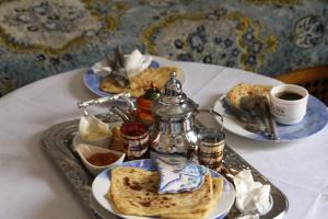 Gite La belle vue Timichi في Timichchi: طاولة مع أطباق من الطعام وكوب من القهوة