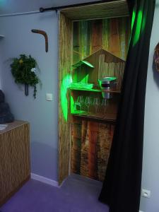 a room with a wooden wall with green lights at Virtuel Spa in Achicourt