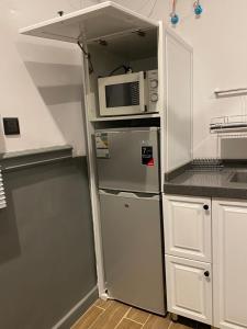 a kitchen with a refrigerator and a microwave at ALULA WINTER in Al-ʿUla