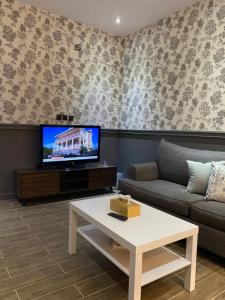 a living room with a couch and a tv at ALULA WINTER in Al-ʿUla