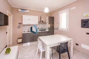 a kitchen with a white table and chairs at Villa Ricky, a pochi passi dal mare in Lascari