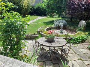 a table and chairs in a garden with a fountain at Suite privative terrasse in Alençon