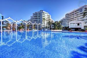a large swimming pool with buildings in the background at Benalbeach loft in Benalmádena