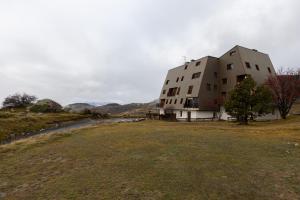 un edificio en una colina con un campo de césped en Carols, en Font-Romeu-Odeillo-Via