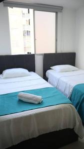 Cette chambre comprend 2 lits et un oreiller. dans l'établissement Encantador y Cómodo apartamento en condominio, à Cúcuta