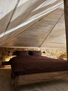 een bed in een kamer met een houten plafond bij Luxury Live in Kamjanets-Podilsky