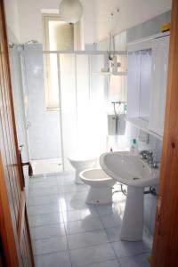 Baño blanco con lavabo y aseo en Villa Gabriella, en Patti