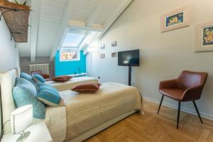a bedroom with a bed and a chair at MEMA HOLIDAY HOME in Aosta