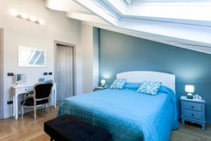 a blue bedroom with a bed and a desk at MEMA HOLIDAY HOME in Aosta