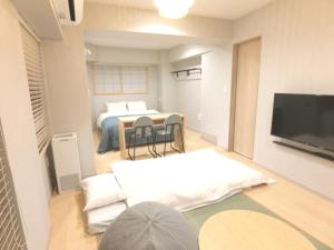 a living room with a bed and a tv in a room at KLASSO Tokyo Sumiyoshi Apartments in Tokyo