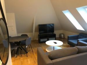 sala de estar con sofá y TV en Fløyen Apartment, en Bergen