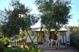 a cottage with a table and chairs on a porch at Domaine Sainte Veziane in Bessan