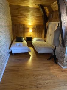 Habitación con 2 camas, paredes de madera y suelo de madera. en La casa du Cerisier en Veyrier-du-Lac