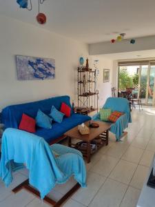 - un salon avec des canapés bleus et une table dans l'établissement Searenity Seafront house - 50m from the beach, à Larnaka