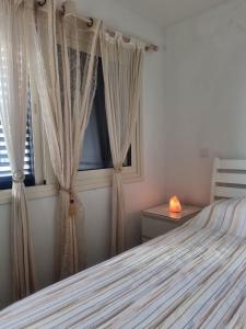 una camera con letto e finestra con tende di Searenity Seafront Beach House a Larnaka
