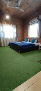 Pokój z 2 łóżkami i zielonym dywanem w obiekcie BlueStays Hostel w mieście Rishikesh