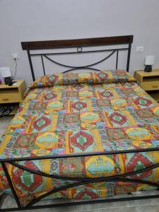 Una cama con una manta de colores encima. en La Tenuta dell 'Orta, en Bolognano