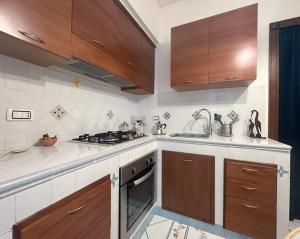 a kitchen with wooden cabinets and a stove top oven at Pagina Storica di Napoli in Naples