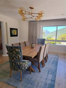 comedor con mesa de madera y sillas en Villa with exquisite mountain and sea views…, en Ciudad del Cabo