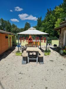 uma mesa de piquenique e um guarda-chuva num quintal em La Tenuta dell 'Orta em Bolognano