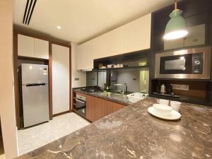 a kitchen with a counter top with a sink and a refrigerator at Anggun Residence Modern Suites with Netflix 3Mins to Monorail KL Near KLCC in Kuala Lumpur