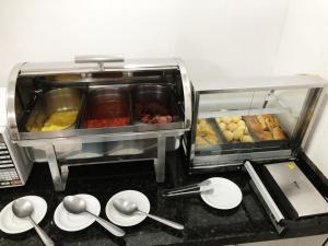 a kitchen counter with utensils and dishes on a counter top at Hotel Ceolatto in Várzea Grande +11 photos