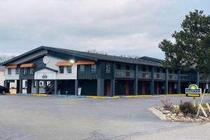 a large building with a parking lot in front of it at Days Inn and Suites by Wyndham Port Huron in Port Huron