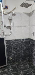 um chuveiro numa casa de banho com azulejos pretos e brancos em Green Leaf Holiday Bungalow em Ratnapura