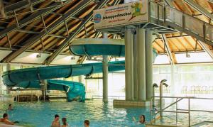 a group of people in a swimming pool with a water slide at Luett Huus in Gartow
