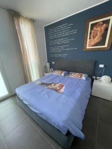 1 dormitorio con 1 cama azul grande y pared en Casa Mina, en Assago