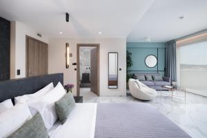 a bedroom with a large bed and a living room at Enattica Suites in Athens