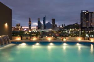 a swimming pool with a city skyline at night at Hyatt Place Monterrey Valle in Monterrey