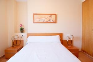 ein Schlafzimmer mit einem großen weißen Bett mit zwei Nachttischen in der Unterkunft Global Properties, Apartamento en Marjal de Corinto con Piscina in Sagunt