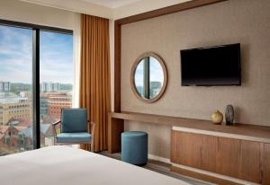 a hotel room with a bed and a tv and a chair at Hyatt Regency Birmingham in Birmingham