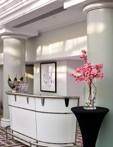 a dining room with a white buffet and a vase of pink flowers at Hyatt Regency Birmingham in Birmingham