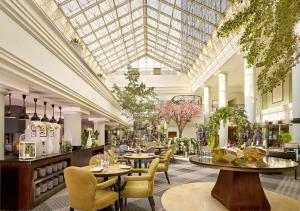 a lobby with tables and chairs and a glass ceiling at Hyatt Regency Birmingham in Birmingham
